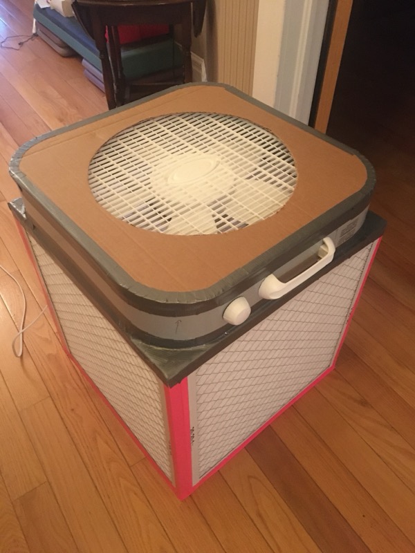 A Corsi-Rosenthal box: a box fan with four MERV-13 furnace filters taped to the sides, creating a low-cost air purifier